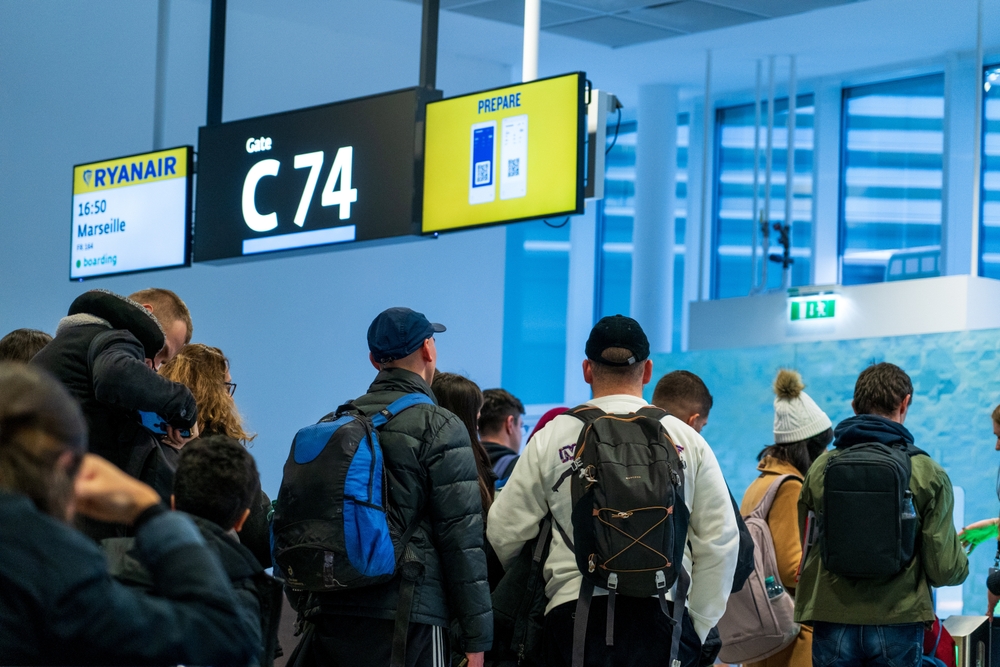 Passagiere warten am Abfluggate am Flughafen Wien Schwechat